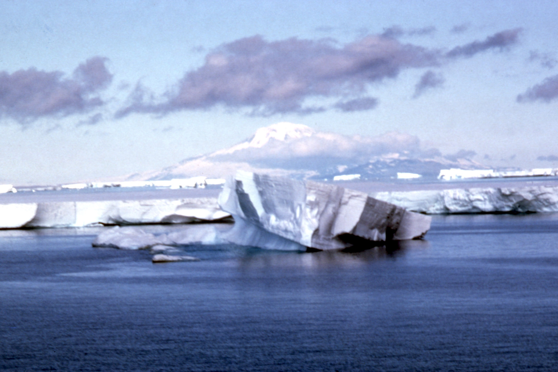 An iceberg floats past an ice shelf in the North Atlantic